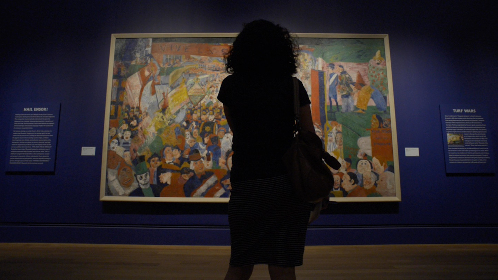 Woman standing in front of large picture in an art gallery